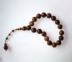 Bild eines braunen Rosenkranzes vor weißem Hintergrund.